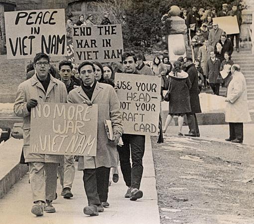 svart-hvitt bilde av demonstranter som holder plakater der det blant annet står "no more war in Vietnam".