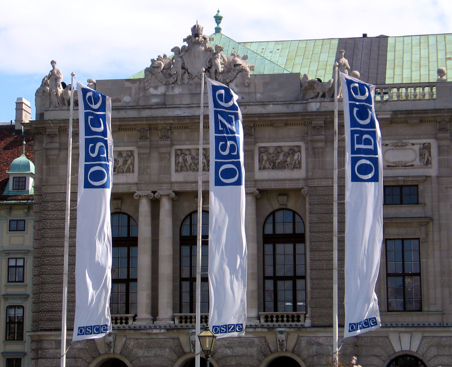 Tre OSSE-bannere henger foran et flott gammelt bygg