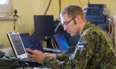 Soldat sitter ved en PC
