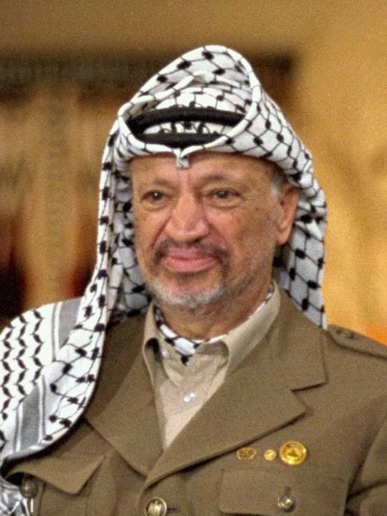 Nærbilde av Arafat ikledd uniform og med palestinaskjerf knyttet rundt hodet.