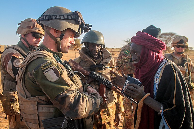 Soldater prater med en sivil mann. I bakgrunnen skimtes ørkenlandskap