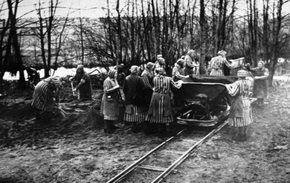 Kvinnelige fanger kledd i stripete klær arbeider langs en jernbanelinje.