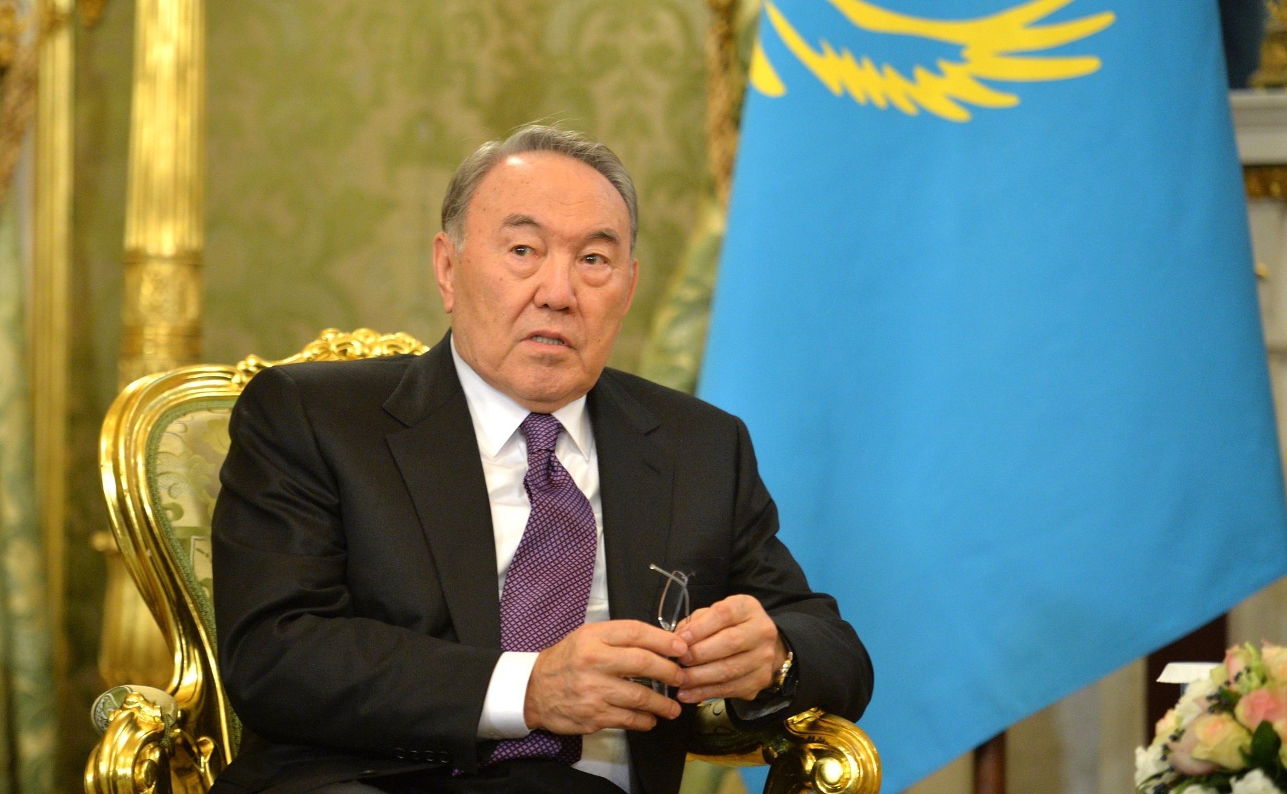Nazarbayev sitter i en gullstol foran et kasakhstansk flagg