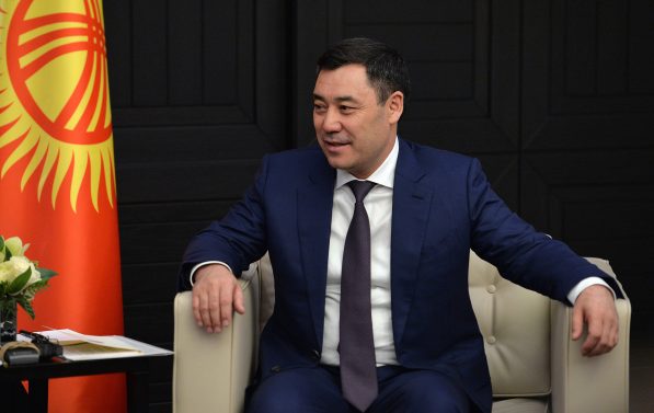 Japarov sitter i en lenestol foran det kirgisiske flagget