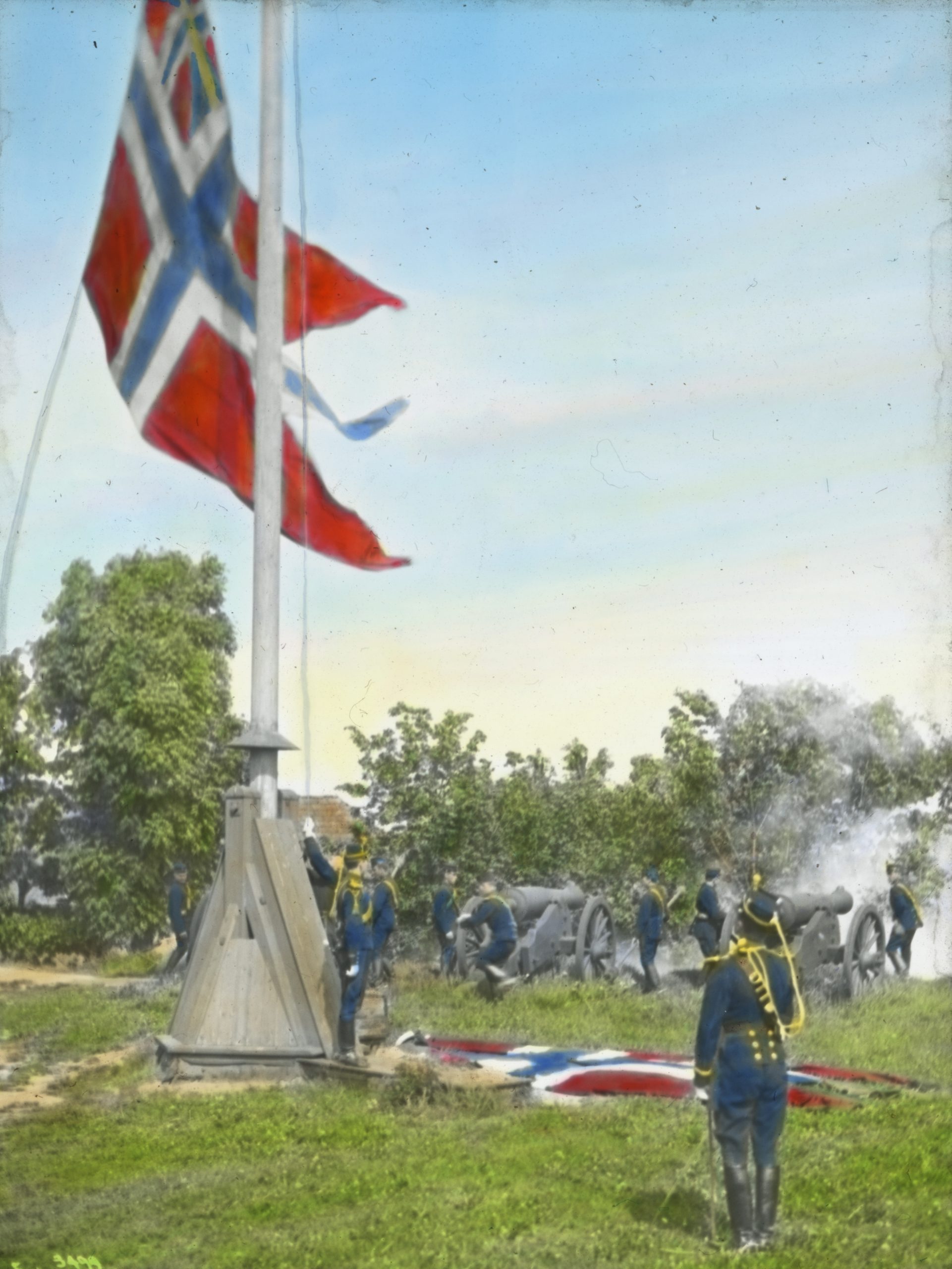 Et flagg senkes med soldater til stede. Kanoner ses i bakgrunnen