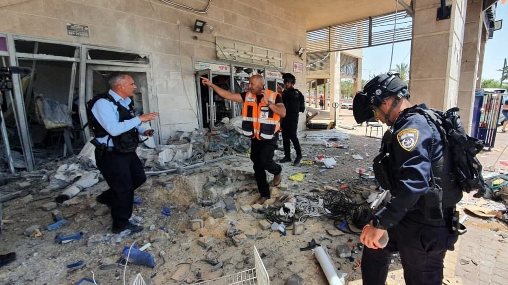 Israelske nødetater foran en ødelagt bygning