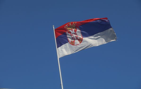 Det serbiske flagget mot en blå himmel