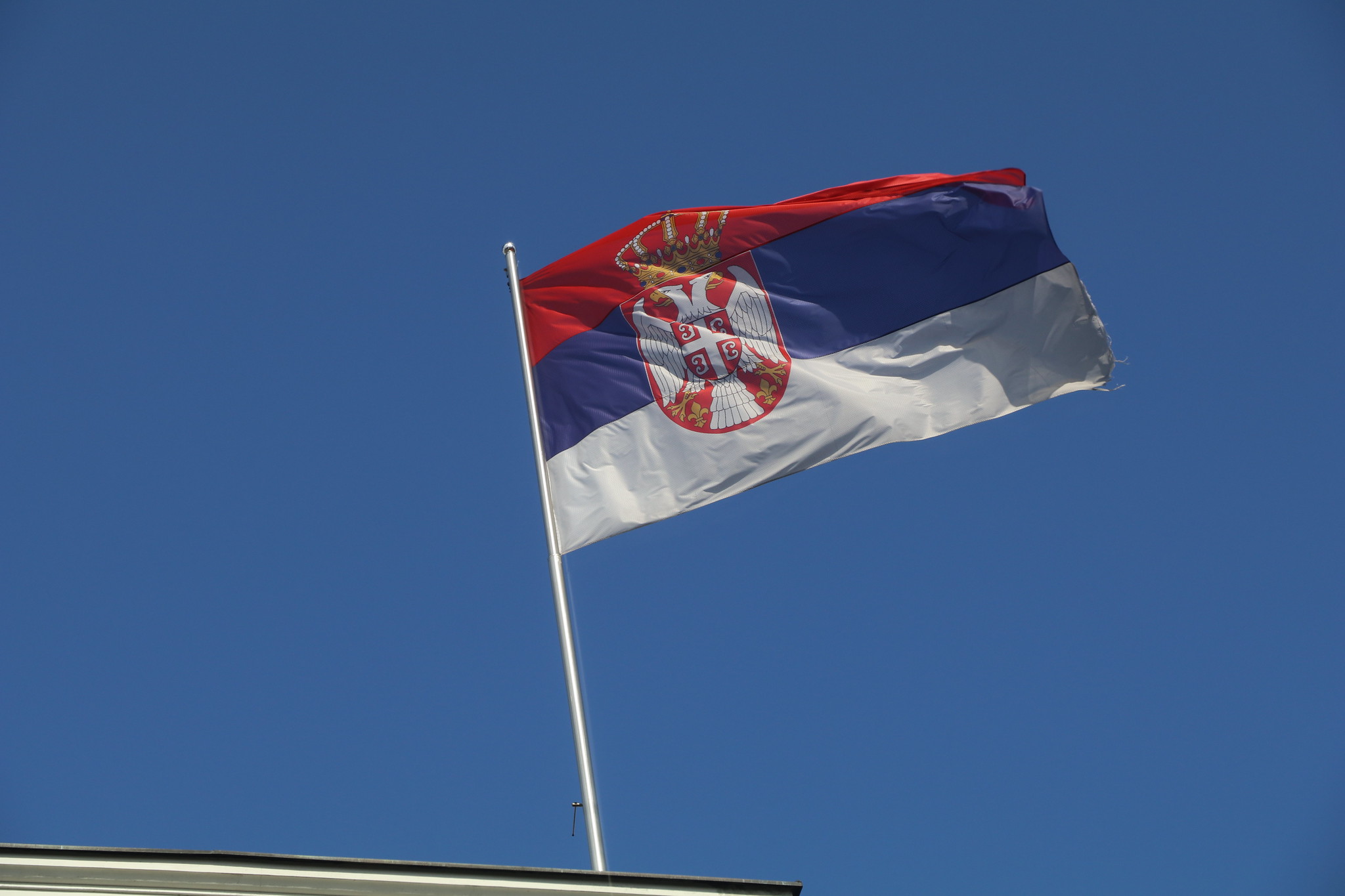 Det serbiske flagget mot en blå himmel