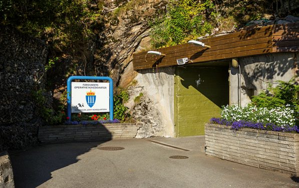 Bilde av inngang i fjellet, med et skilt utenfor.