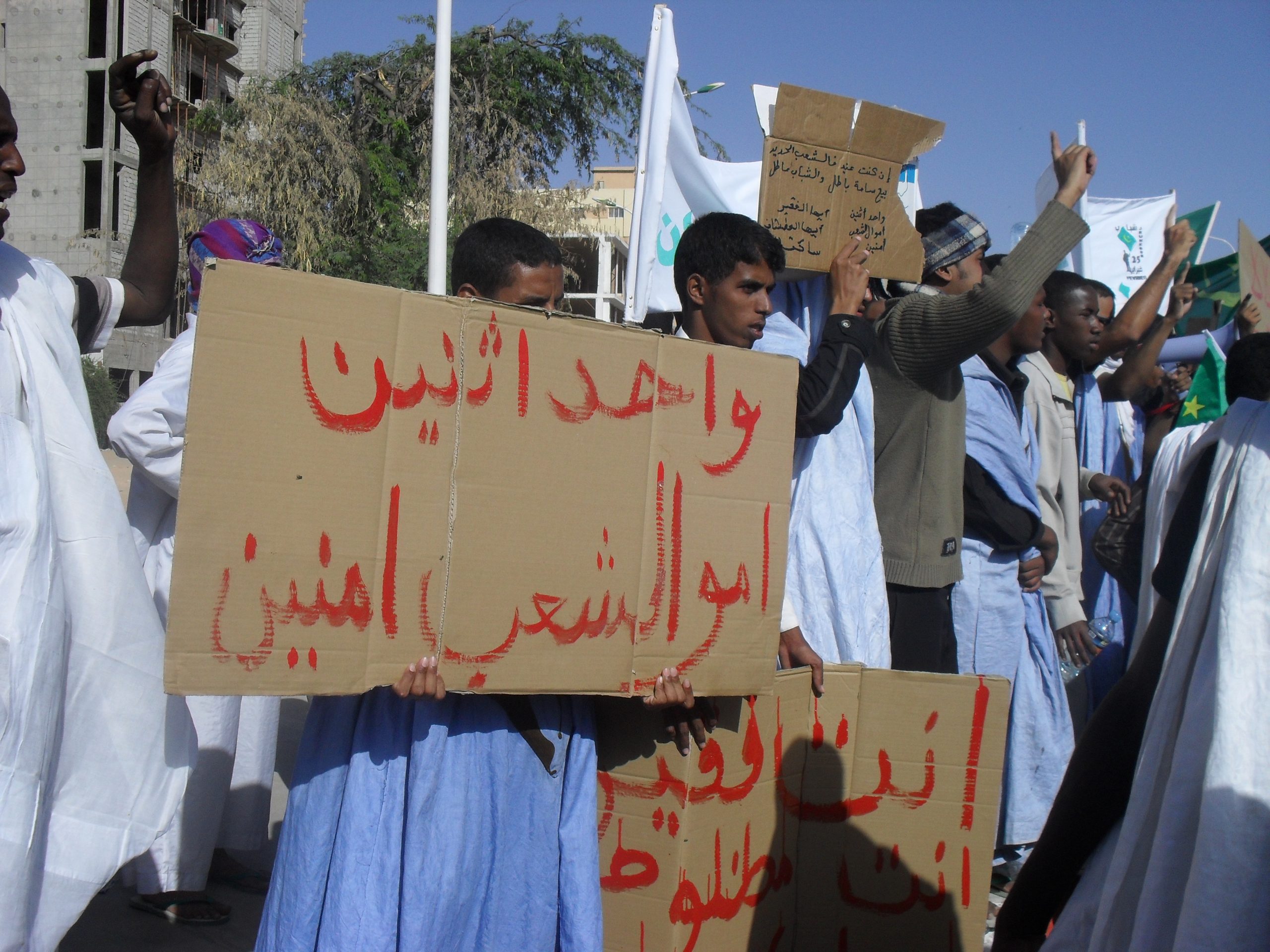 Mennesker demonstrerer med plakater med arabisk skrift