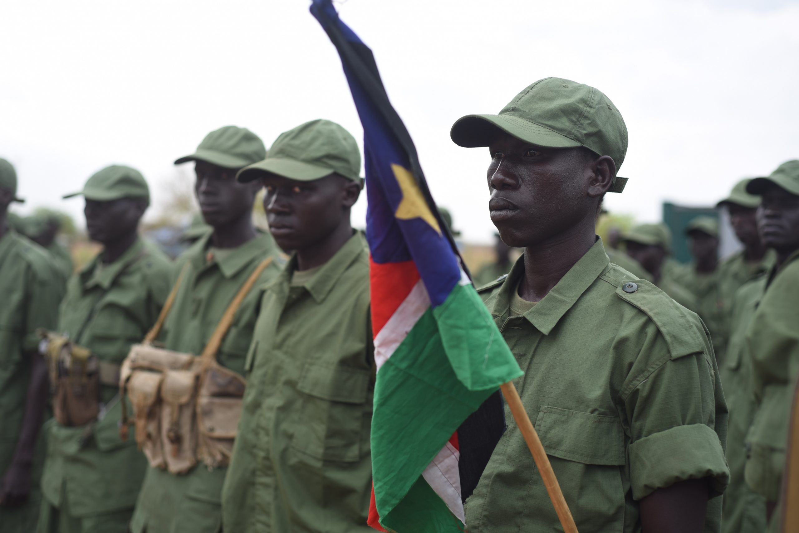 Soldater står på rekke og holder det sør-sudanske flagget. 