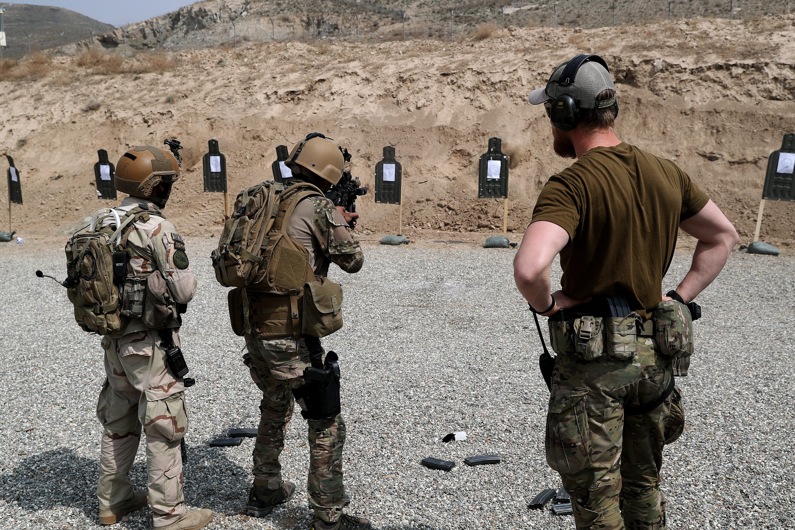En norsk spesialsoldat fra Marinejegerkommandoen observerer to afghanske soldater som øver på å skyte på blinker.