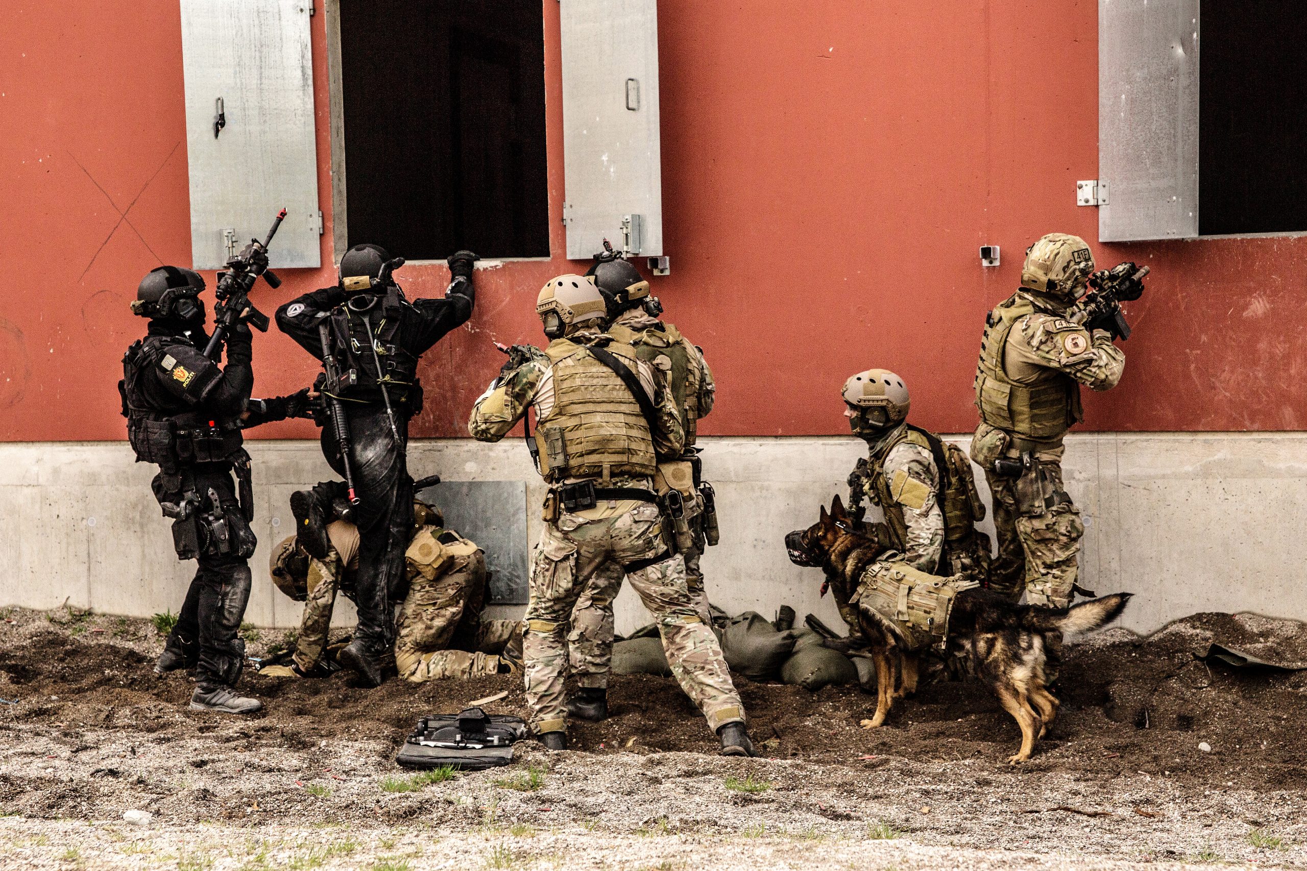 To svartkledde politimenn fra Beredskapstroppen og fem uniformskledde soldater fra Spesialkommandoen og Marinejegerkommandoen tar seg inn i et bygg under øvelse.