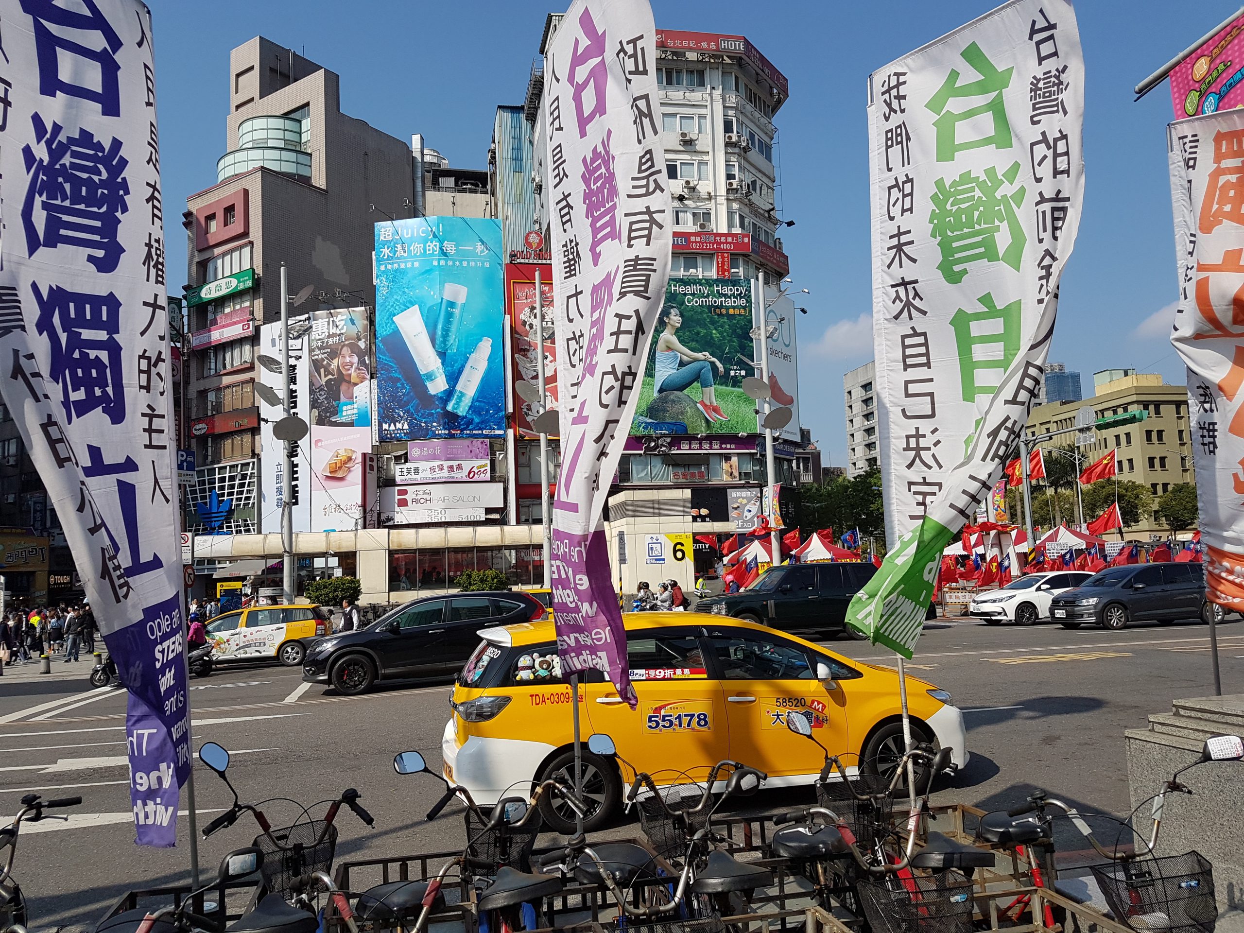 Mangefargede bannere langs en gate i Taipei viser slagord om Taiwan-stredet.