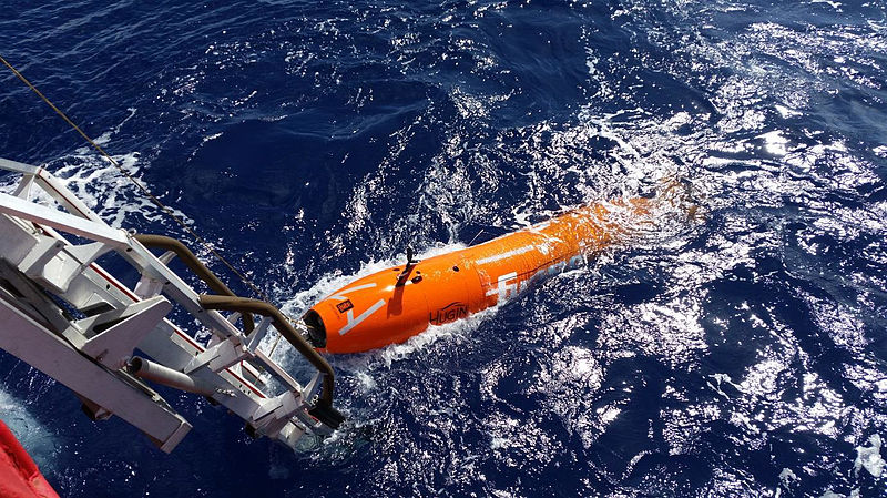 En oransje og liten, ubemannet undervannsfarkost, ligger i vannet for testing.