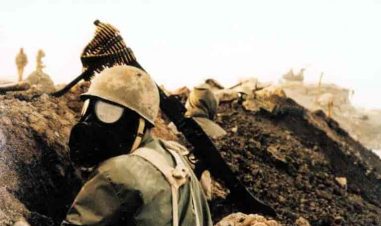 bildet viser en soldat med gassmaske som sitter bak en skyttegrav